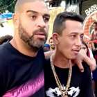 Adriano Imperador sai amparado por um amigo de baile funk