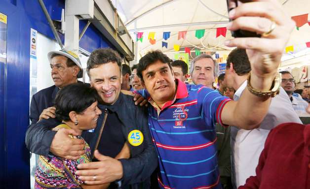 Em centro nordestino no Rio, Aécio faz repente e tira selfie