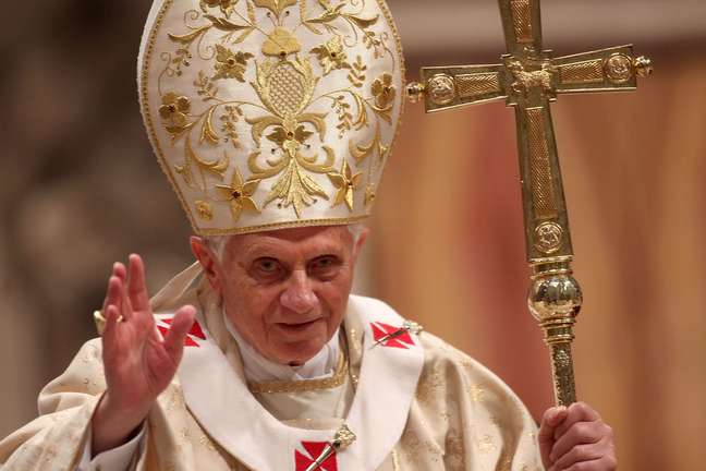 <p>Papa Bento XVI acena para católicos na basílica de São Pedro em missa realizada em 2011</p>