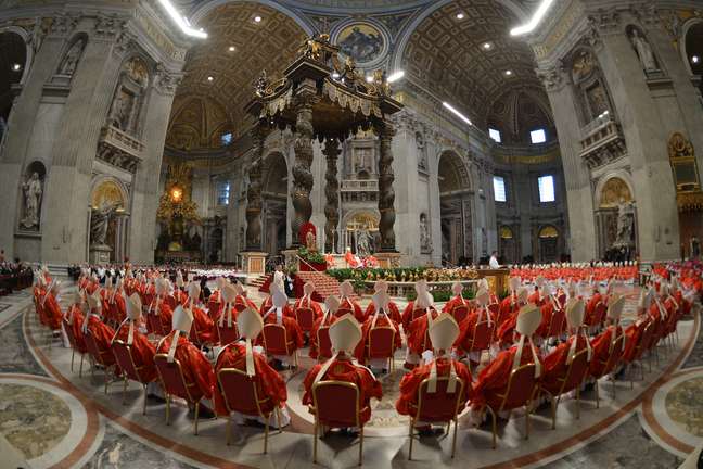 <p>De vermelho e sentados, cardeais acompanham a missa <em>Pro Eligendo Pontifice</em> na manhã desta terça-feira</p>