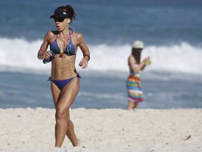 <p>A atriz Carla Marins pratica corrida na praia</p>