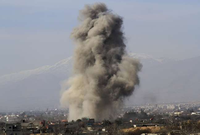 Nuvem de fumaça sobre Daraya após o lançamento de bombas por tropas do governo sírio