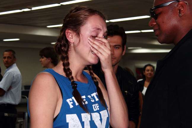 Modelo chora após desembarcar no aeroporto de São Paulo. Ela deve se dirigir a Santa Catarina para se encontrar com a família