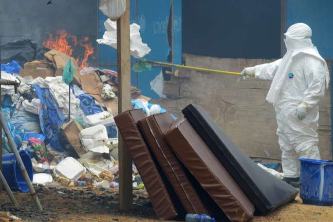 Agente de saúde queima objetos pertencentes a infectados por ebola na Libéria