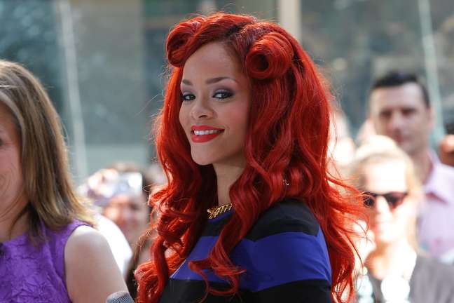 Rihanna já estava chamando atenção com o longo vermelho e exagerou com os rolinhos na lateral do cabelo  