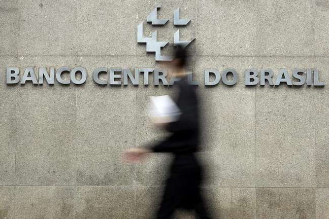 <p>Homem passa pela logomarca do Banco Central na sede do banco em Bras&iacute;&shy;lia</p>