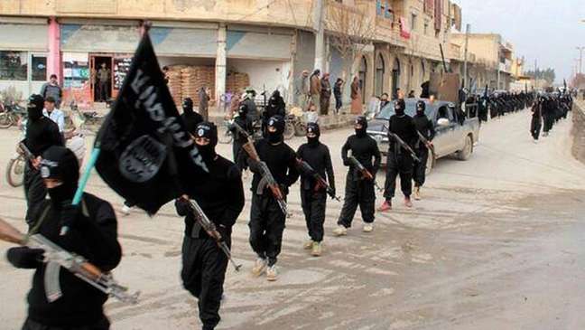 <p>Combatentes do grupo Estado Islâmico marcham em Raqqa, na Síria</p>