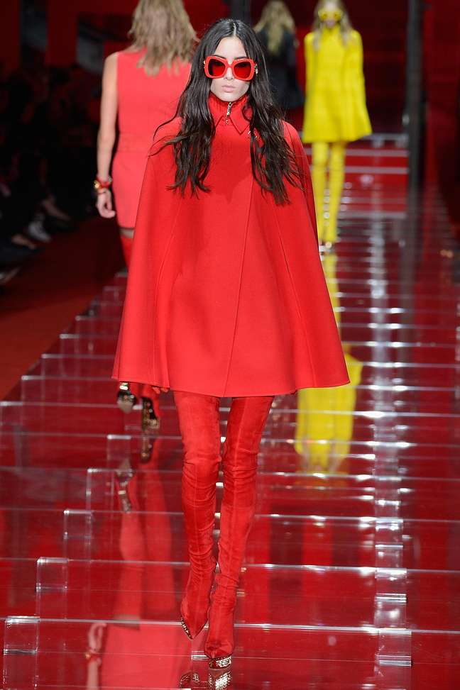 <p>Casaco tipo pelerine, lembrando os anos 60, é a proposta da Versace, também em tom vermelho</p>