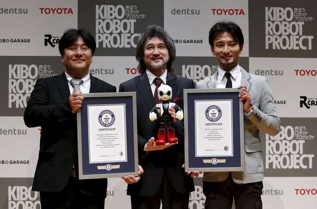 Sócios responsáveis pela criação do robô astronauta japonês Kirobo posam para fotos juntos dos certificados concedidos pelo Guinness Book