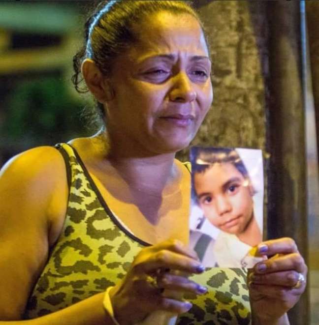 A mãe de Eduardo de Jesus Ferreira, 10 anos, segura a foto da criança, baleada no complexo do Alemão