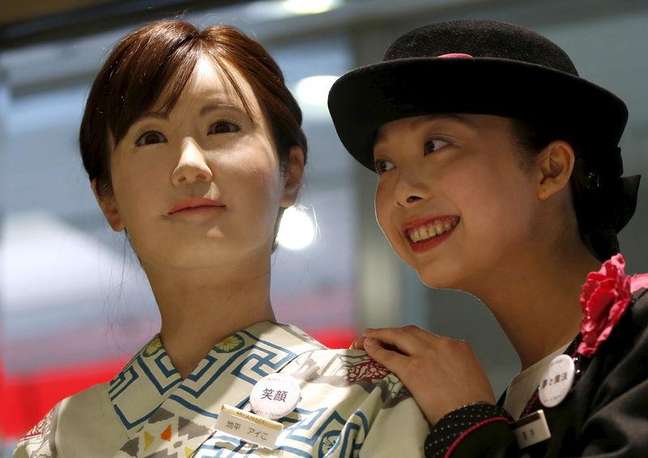 Uma atendente da loja de departamento japonesa Nihonbashi Mitsukoshi posa ao lado do robô humanoide Aiko Chihira, desenvolvido pela Toshiba, em Tóquio  20/042015.