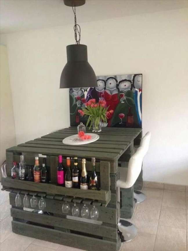 Pallets pintados se transformam em uma mesa com detalhe lateral para guardar garrafas e taças