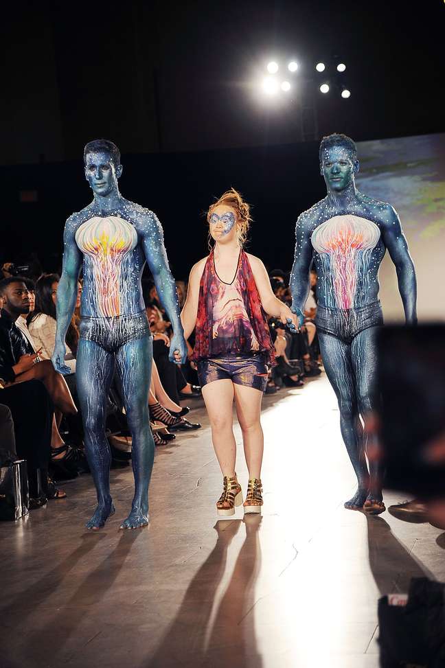 Madeline Stuart fez outra entrada para Hendrick Vermeulen, com shorts e camiseta, ao lado de dois modelos com pinturas que remetem aomfilme Avatar