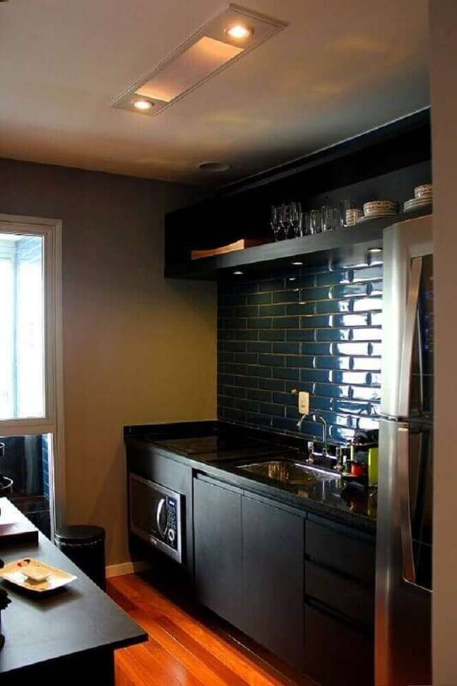 52. Cozinha planejada preta com ladrilho hidráulico e piso de madeira
