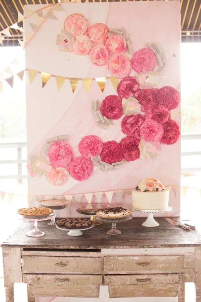 11. Mesa de doces com fundo com flores de papel rosa