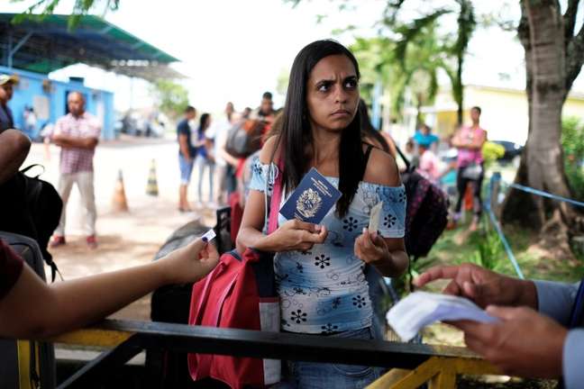 Venezuelana mostra passaporte e carteira de identidade em posto de controle de fronteira em Pacaraima, em Roraima
13/04/2018 REUTERS/Nacho Doce