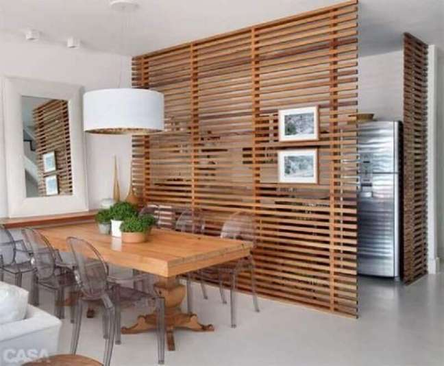 41. Painel com vigas de madeira como divisória para sala de jantar com cadeiras de acrílico transparente