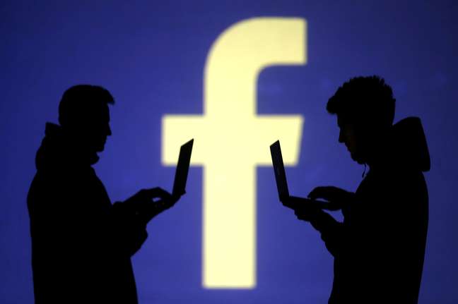 Pessoas usam computadores diante de projeção do logo do Facebook em foto ilustativa
28/03/2018 REUTERS/Dado Ruvic/Illustration