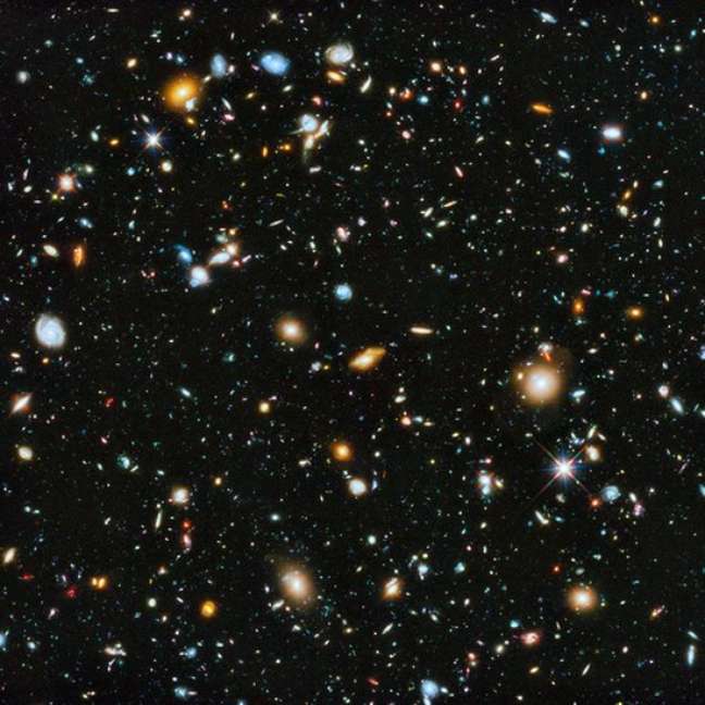 Esta imagem impactante, conhecida como Campo Ultra Profundo do Hubble, é uma montagem de fotos tiradas ao longo de mais de um ano. O que estamos vendo é o Universo quando a luz partiu até alcançar o Hubble, há 13 milhões de anos