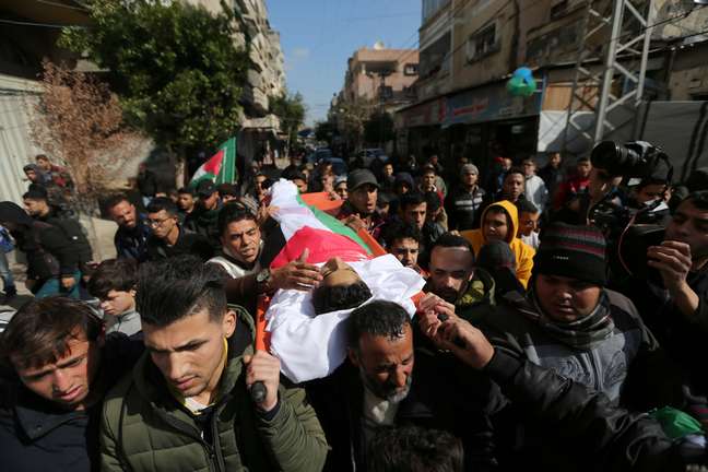 Corpo do adolescente palestino Hassan Shalabi, 14, morto durante protesto na fronteira entre Israel e Gaza, é carregado durante funeral na região central de Gaza.
