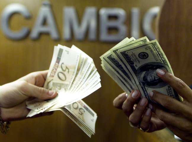 Pessoas contam notas de reais e dólares em casa de câmbio
04/08/2003
REUTERS/Bruno Domingos