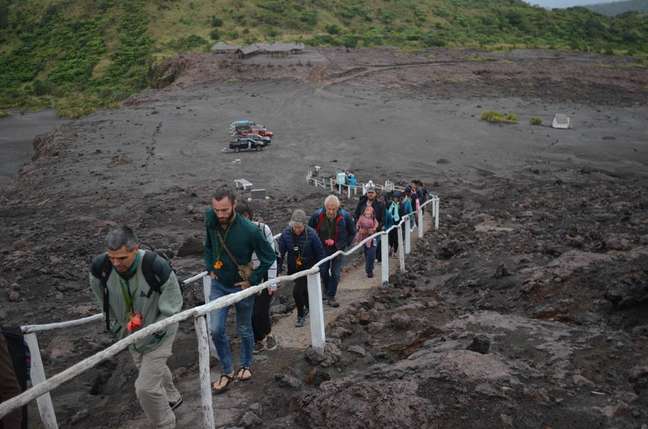 Carros ficam no centro de visitantes; grupo segue por uma trilha curta até a cratera