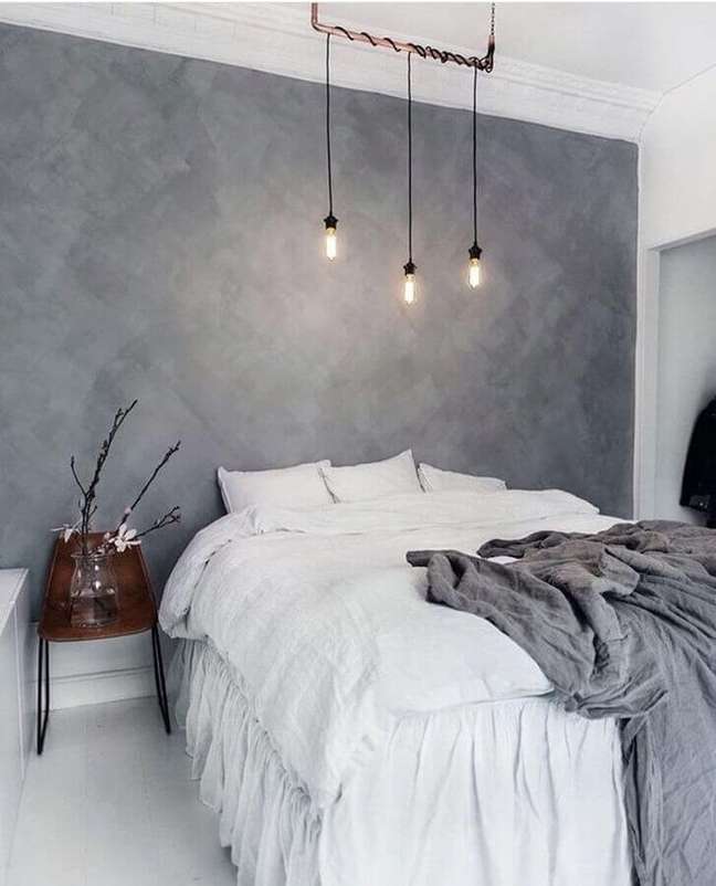 16. Decoração minimalista com pendente para quarto de casal com parede de cimento queimado – Foto: Decoredo