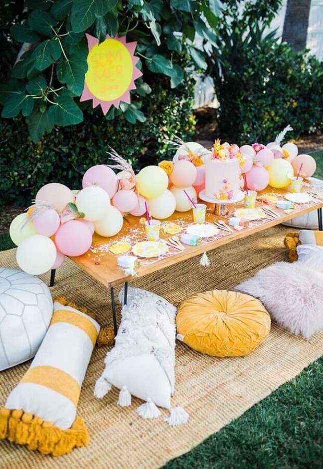 15. Decoração de aniversário piquenique com arranjo de balões e almofadas diferentes – Foto: