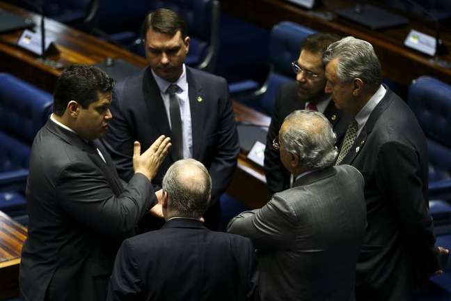 O presidente do Senado, Davi Alcolumbre, conversa com os senadores Tasso Jereissati e Flavio Bolsonaro em sessão de votação da reforma da Previdência.