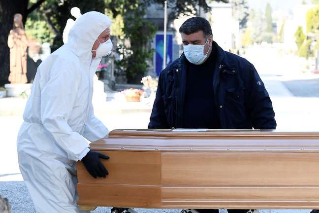 Homens com máscara e roupa de proteção transportam caixão para cemitério em Bergamo
16/03/2020
REUTERS/Flavio Lo Scalzo
