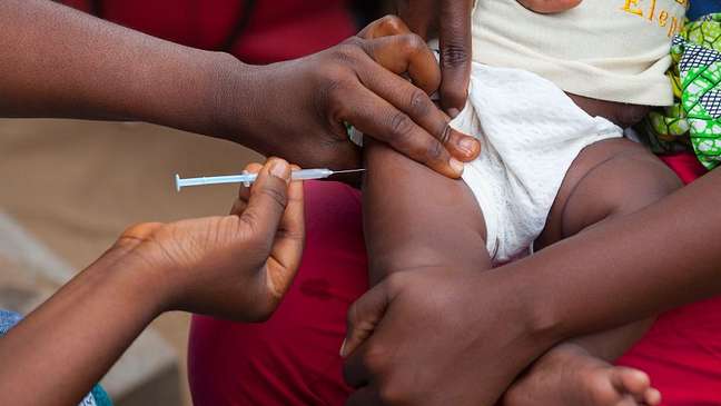 Vacina contra hepatite B (acima, sendo ministrada no Congo) é um dos exemplos de imunização que levaram mais tempo a chegar aos países mais pobres