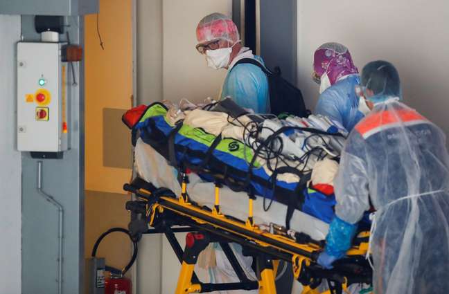 Trabalhadores da saúde transportam um paciente em uma maca no hospital Pontchaillou de Rennes, durante uma operação de transferência de pessoas infectadas com a doença Covid-19 do Hospital da Região de Paris para Britanny, na França. 01/04/2020. REUTERS/Stephane Mahe.