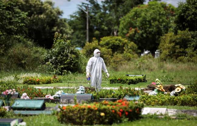 Um coveiro é visto durante o enterro de Ester Melo da Silva, 67 anos, que morreu em razão da doença por coronavírus (COVID-19), no cemitério Parque Tarumã em Manaus, AM, Brasil. 10/04/2020. REUTERS/Bruno Kelly 