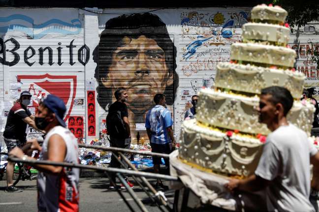 Pessoas passam em frente a grafite de Maradona em Buenos Aires
27/11/2020 REUTERS/Ricardo Moraes