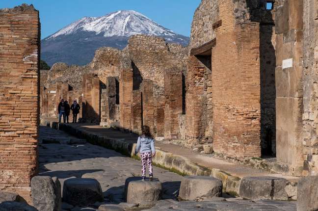 Turista usa máscara contra a covid-19 entre as ruas das escavações arqueológicas de Pompéia no primeiro dia da reabertura 