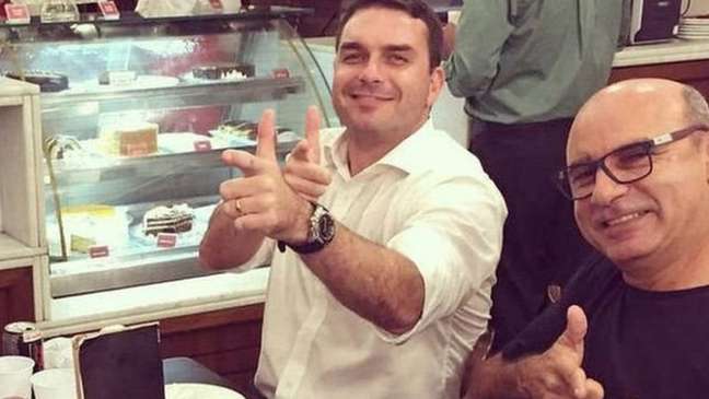 Queiroz (à dir.) é ex-motorista e ex-segurança do hoje senador Flávio Bolsonaro, filho do presidente