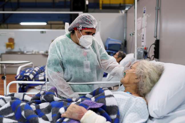 Enfermeira de um hospital em Santo André, no Estado de São Paulo, conversa com paciente idosa. 01/01/2021. REUTERS/Amanda Perobelli. 

