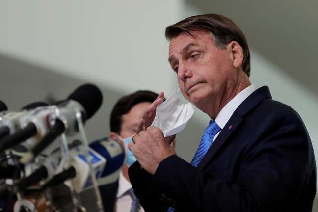 O presidente do Brasil, Jair Bolsonaro, tira a máscara antes de falar à mídia sobre a ajuda financeira emergencial do governo federal durante a crise do coronavírus (COVID-19) no Palácio do Planalto, em Brasília