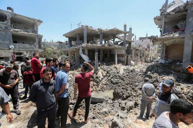 Palestinos se reúnem perto de casas destruídas por ataques aéreos e de artilharia de Israel no norte da Faixa de Gaza
14/05/2021 REUTERS/Mohammed Salem