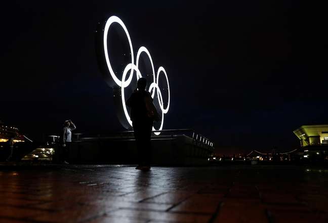 Visitantes tiram fotos na frente de anéis olímpicos instalados em Yokohama para celebração da disputa dos Jogos de Tóquio