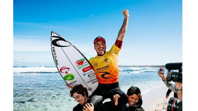 Gabriel Medina comemora triunfo de sua carreira com a prancha repleta de patrocinadores (Foto: Matt Dunbar / World Surf League)
