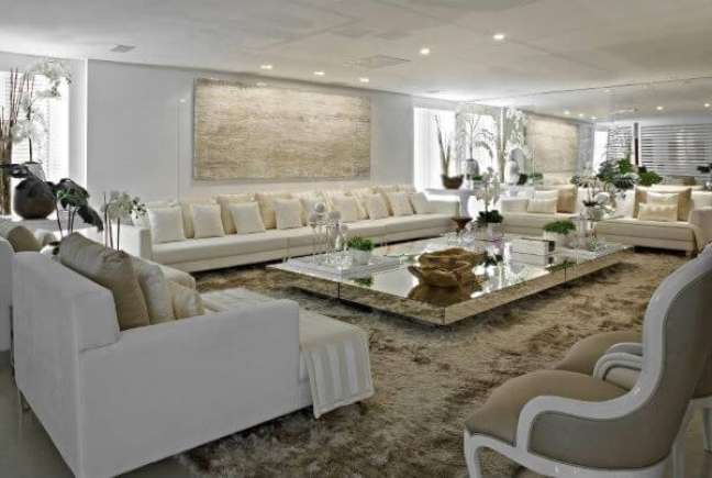 4. Sala grande decorada com sofás bege e mesa de centro espelhada – Projeto Jose Roberto Verona