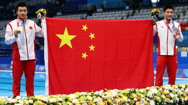 Cao Yuan e Yang Jian celebram medalhas de ouro e prata segurando a bandeira da China Stefan Wermuth/Reuters