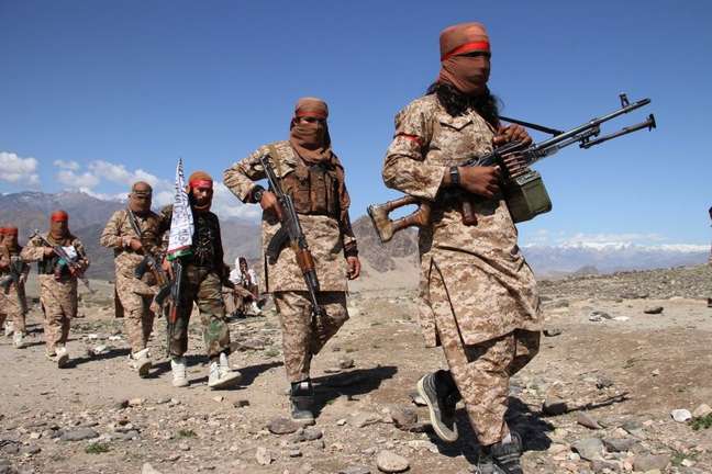 Soldados armados do Talebã e civis comemoram acordo de paz em 2020