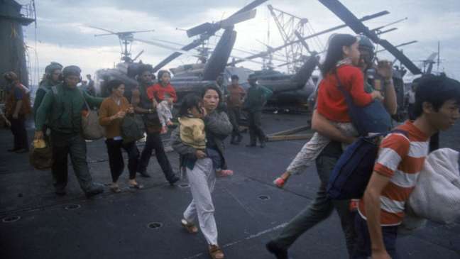 Refugiados vietnamitas embarcam em navio da Marinha dos Estados Unidos, antes da queda de Saigon em abril de 1975
