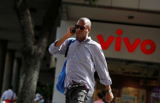 Homem fala ao celular enquanto caminha em frente a uma loja da Vivo, no centro do Rio de Janeiro
REUTERS/Pilar Olivares