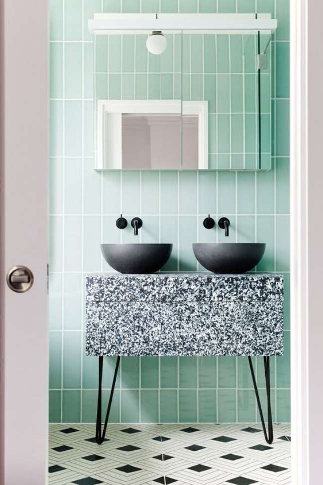 47. Banheiro moderno com revestimento verde pastel e bancada preta e branca – Foto Casa Vogue