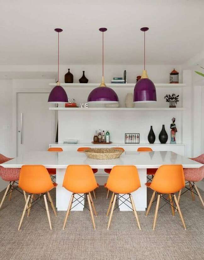 51. Sala de jantar colorida decorada com cadeira laranja e luminária roxa – Foto: Homify