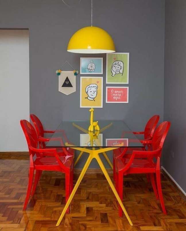 52. Sala de jantar colorida decorada com luminária amarela e cadeiras vermelhas – Foto: Hommes Studio