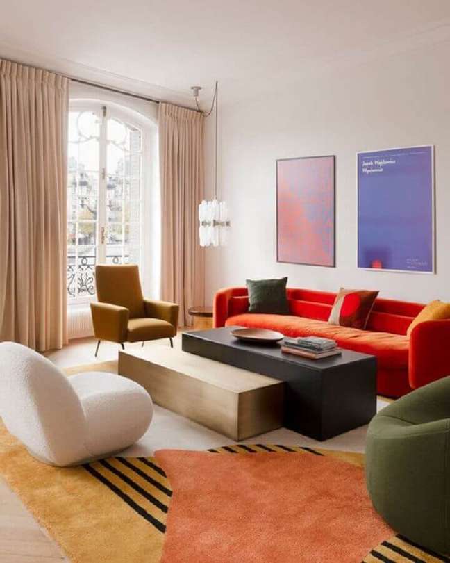 27. Decoração de sala colorida com sofá vermelho e tapete estampado – Foto: Apartment Therapy